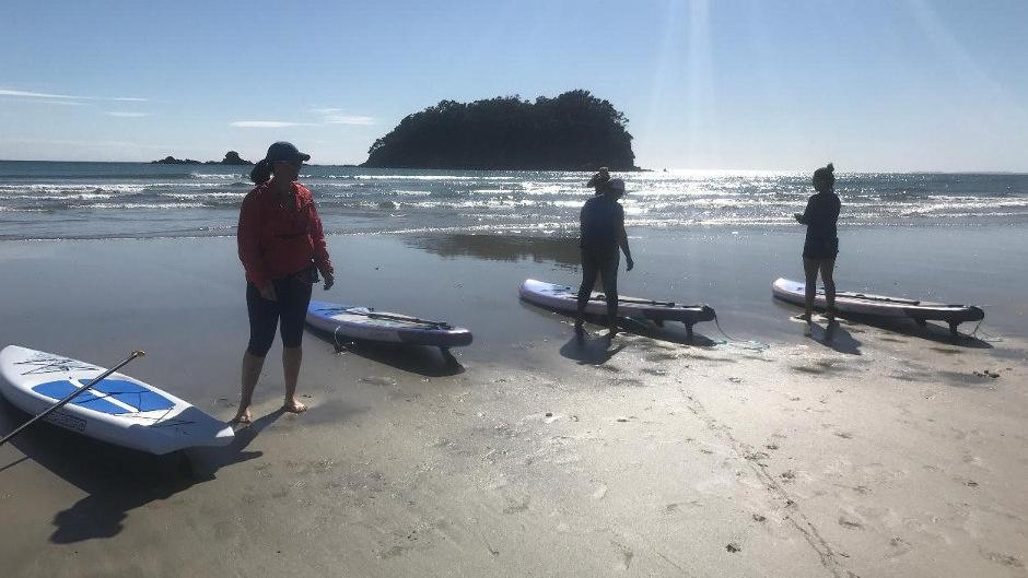 Hop onto a paddleboard and venture into the stunning waters of Pilot Bay in Mount Maunganui!